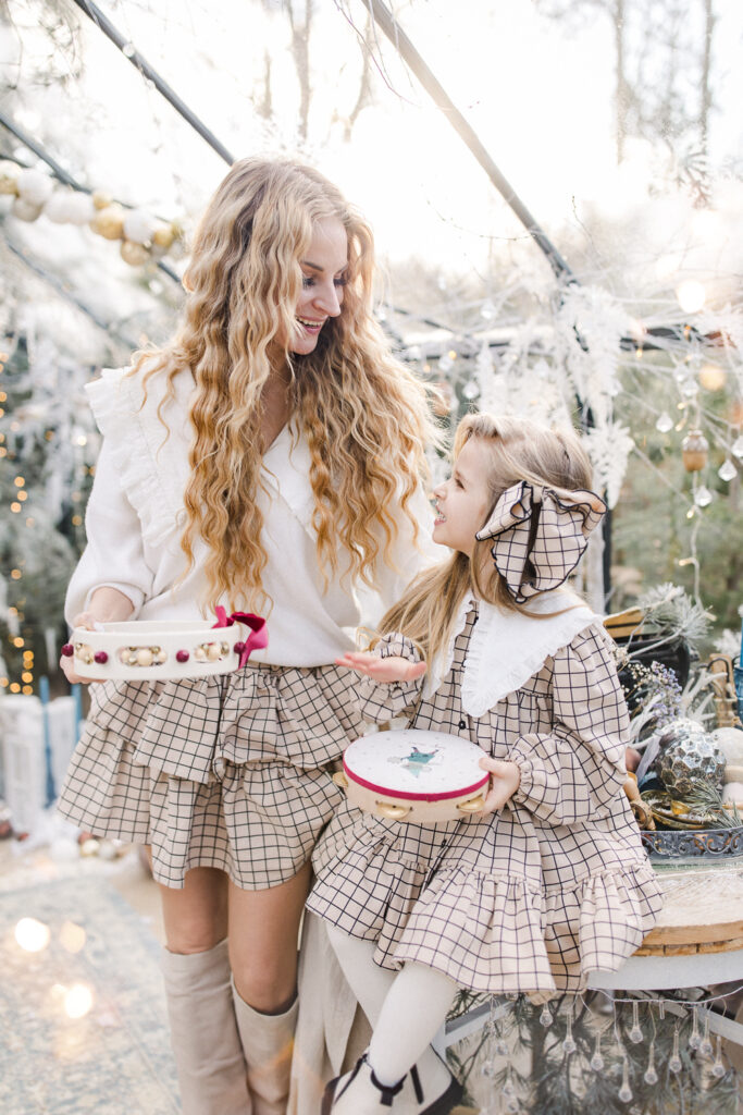 Kobieta w zimowej stylizacji podczas sesji świątecznej w szklarni w Żywcu – elegancka aranżacja, książka i ciepłe światło