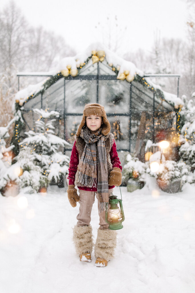 Zimowa sesja świąteczna w szklarni w Żywcu – dziecko w wełnianym płaszczyku i czapce pilotce pośród śnieżnej aranżacji, Szklarniowe Love